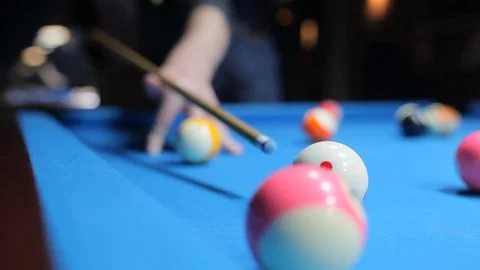 Man Playing Billiard on Blue Pool Table; hits the white ball Stock Footage 82867583