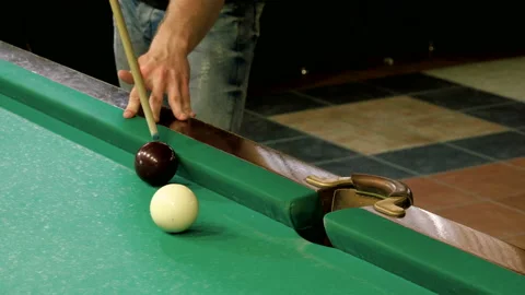Man playing billiards, hitting balls with cue into pockets on billiard table. 4K Stock Footage 109451994