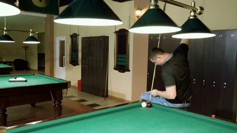 Man playing billiards, hitting balls with cue into pockets on billiard table. 4K Stock-Footage 109452068