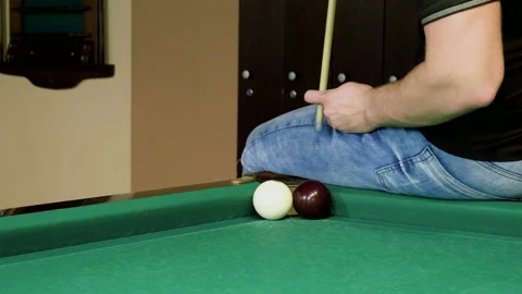 Man playing billiards, hitting balls with cue into pockets on billiard table. 4K Stock Footage 109452078