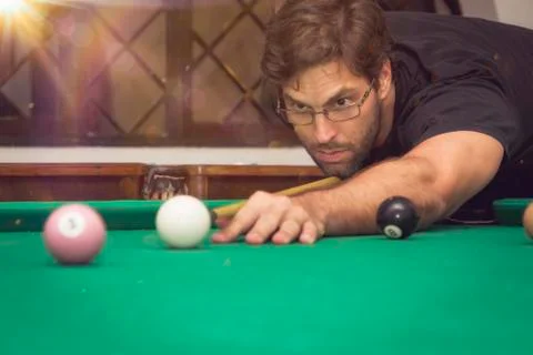 Man playing billiards in a pool table. Stock Photos