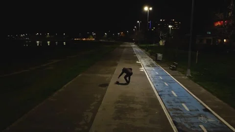 A man playing a cat on the sidewalkds at night Видео 314306933