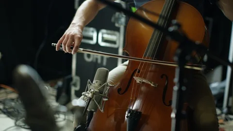 Man playing cello with guitar player in foreground Stock Footage 109269548