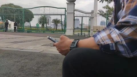 A man playing cellphone at monas Stock Footage 234092626