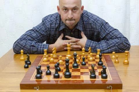 Man playing chess on light background. closeup of young man thinking over mov Stock Photos