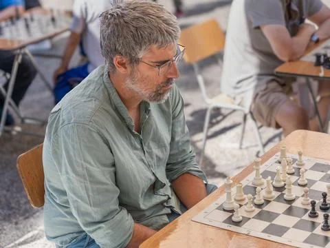 Man playing chess on a street table concentrating on strategy Fotos Stock