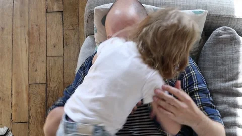 Man playing with a child on the couch. Stock Footage 254909810