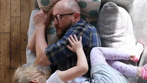 Man playing with a child on the couch. Stock Footage 254911811