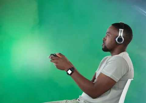 Man playing with computer game controller with green fog background Stock Photos