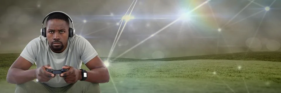 Man playing with computer game controller with light connections on green hills Stock Photos