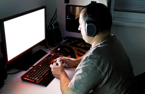 Man playing computer game on custom made desktop with joypad, keyboard, mouse Stock Photos