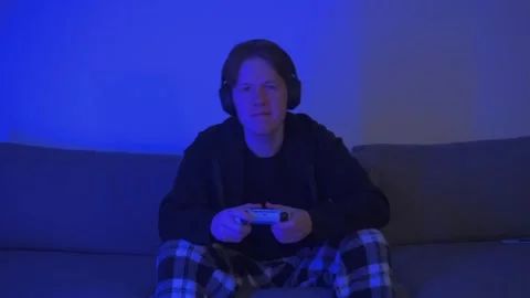 Man playing a console and getting frustrated at losing a video game Stockbeeldmateriaal 274171255