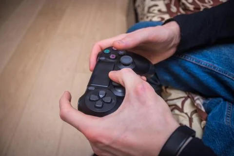 Man is playing on the console game joystick Stock Photos