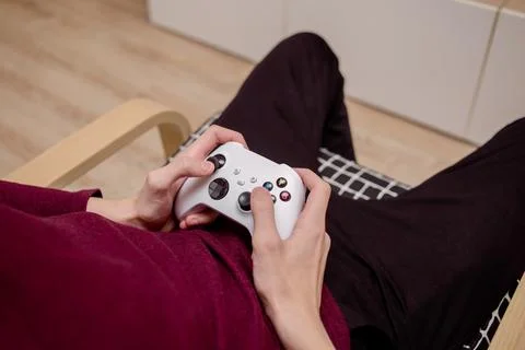 A man playing a console, holding a joystick in his hands Stock Photos