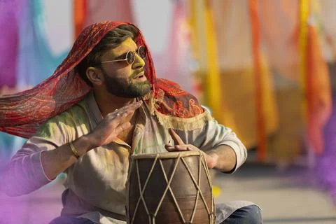 Man playing on a dhol with colored face during holi color festival Stock Photos