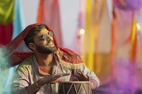 Man playing on a dhol with colored face during holi color festival Stock Photos