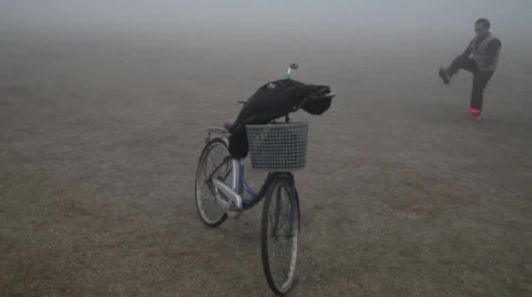 Man playing diabolo in park hazed by mist in the morning Stock Footage 24668867