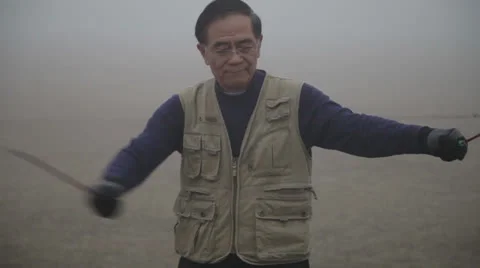 Man playing diabolo in park hazed by mist in the morning Stock Footage 24695194