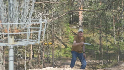 Man playing disc golf in pine forest Video stock 245056606