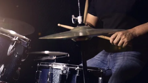 A man is playing drum set in black background with dust in the air. Stock Footage 103604833