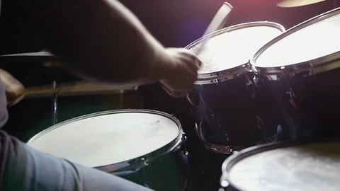 A man is playing drum set in black background with dust in the air. Stock Footage 103606113