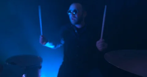 Man Playing the Drums in Slow Motion Illuminated By a Blue Light Stock Footage 98908078