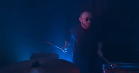 Man Playing the Drums in Slow Motion Illuminated By a Red Light Stock Footage 98908722