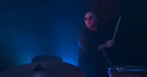 Man Playing the Drums in Slow Motion Illuminated By a Red Light Stock Footage 98909449