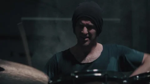 Man playing the drums while sweating in dim room Stock Footage 275101330