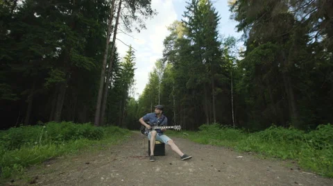 Man is playing at the electric guitar in forest Stock Footage 68348742