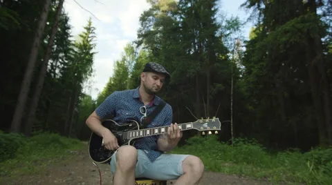 Man is playing at the electric guitar in forest Stock Footage 68348923