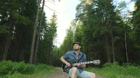 Man is playing at the electric guitar in forest Stock Footage 68350029