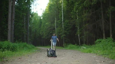 Man is playing at the electric guitar in forest Stock Footage 68353407