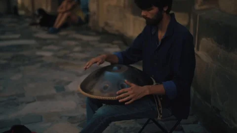 Man playing on a first generationan instrument called '' Hang '' or ''Hang drum' Stock Footage 103625828