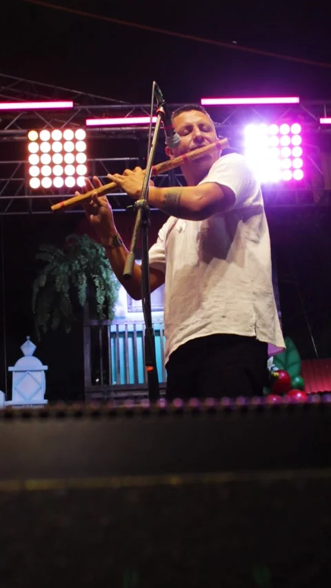 A man playing a flute at an evening event Stock Footage 313297367