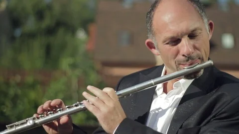 A man is playing a flute in the street. Video stock 80715573