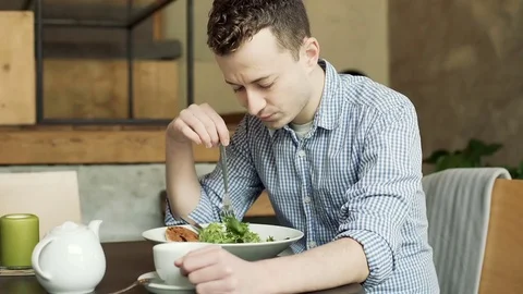 Man playing with food while sitting alone in the cafe and having some problems Vídeos de archivo 72768810