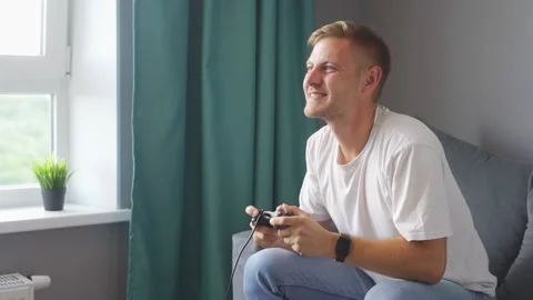 A man playing a game console at home Stock Footage 221260597