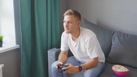 A man playing a game console at home Stock Footage 221260718