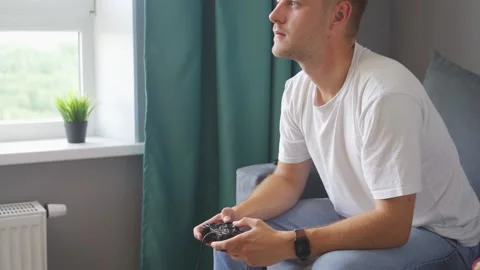 A man playing a game console at home Video stock 221398770