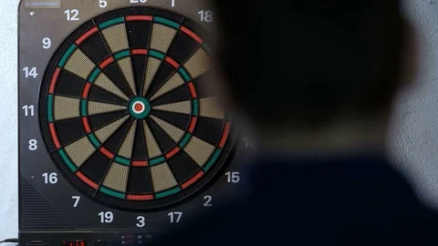 Man playing a game of darts, focus on target Stock Footage 75886332