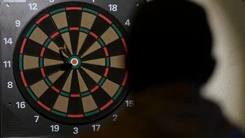 Man playing a game of darts, focus on target Stock Footage 75887267