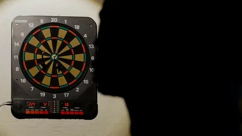 Man playing a game of darts, focus on target Stock Footage 75887577
