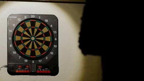 Man playing a game of darts, focus on target Stock Footage 75887860