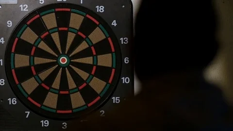 Man playing a game of darts, focus on target Stock Footage 76411530
