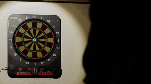 Man playing a game of darts, focus on target Stock Footage 76413431