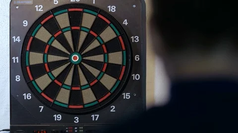 Man playing a game of darts, focus on target Stock Footage 80934064