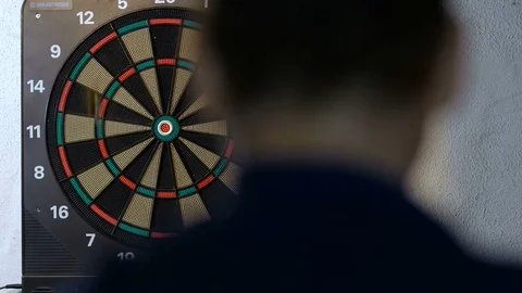 Man playing a game of darts, focus on target Stock Footage 80934728