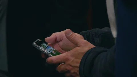 A man playing a game on his mobile phone on public transport in London Stock Footage 88955708