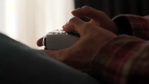 A man playing games on a console at home sitting on the couch. Stock Footage 238479576
